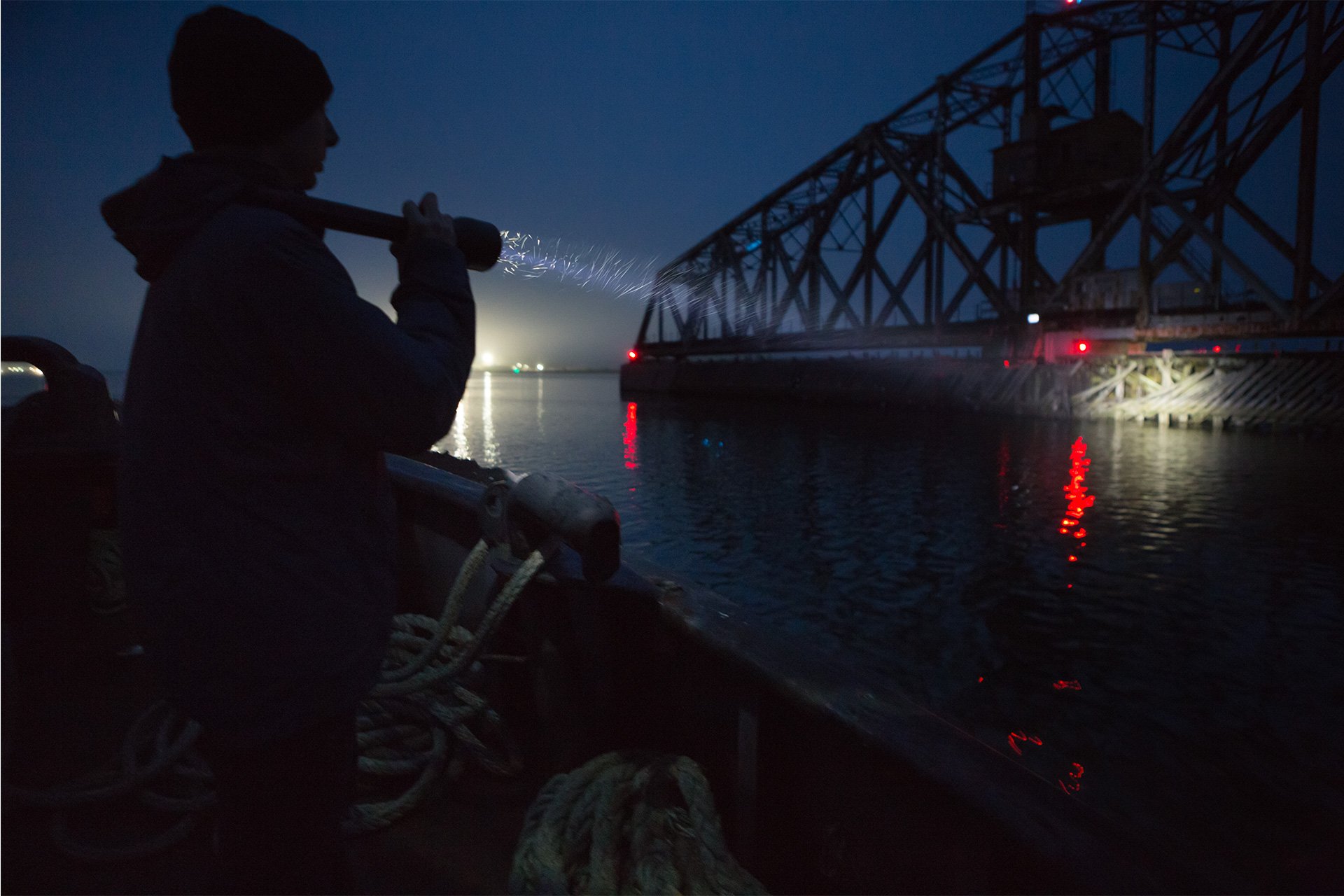 Brand Photography for Coast Products showing man holding long range flashlight beam on bridge