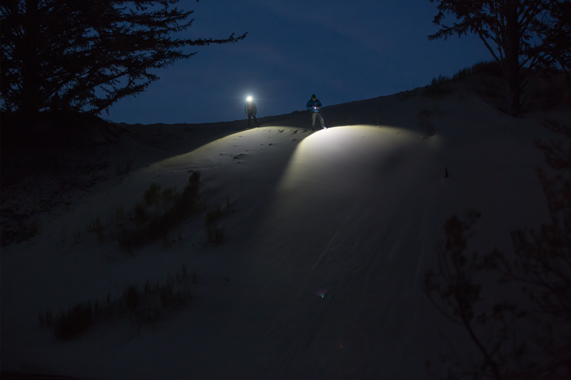 Brand Photography for Coast Products showing two flashlight beams on sand dune