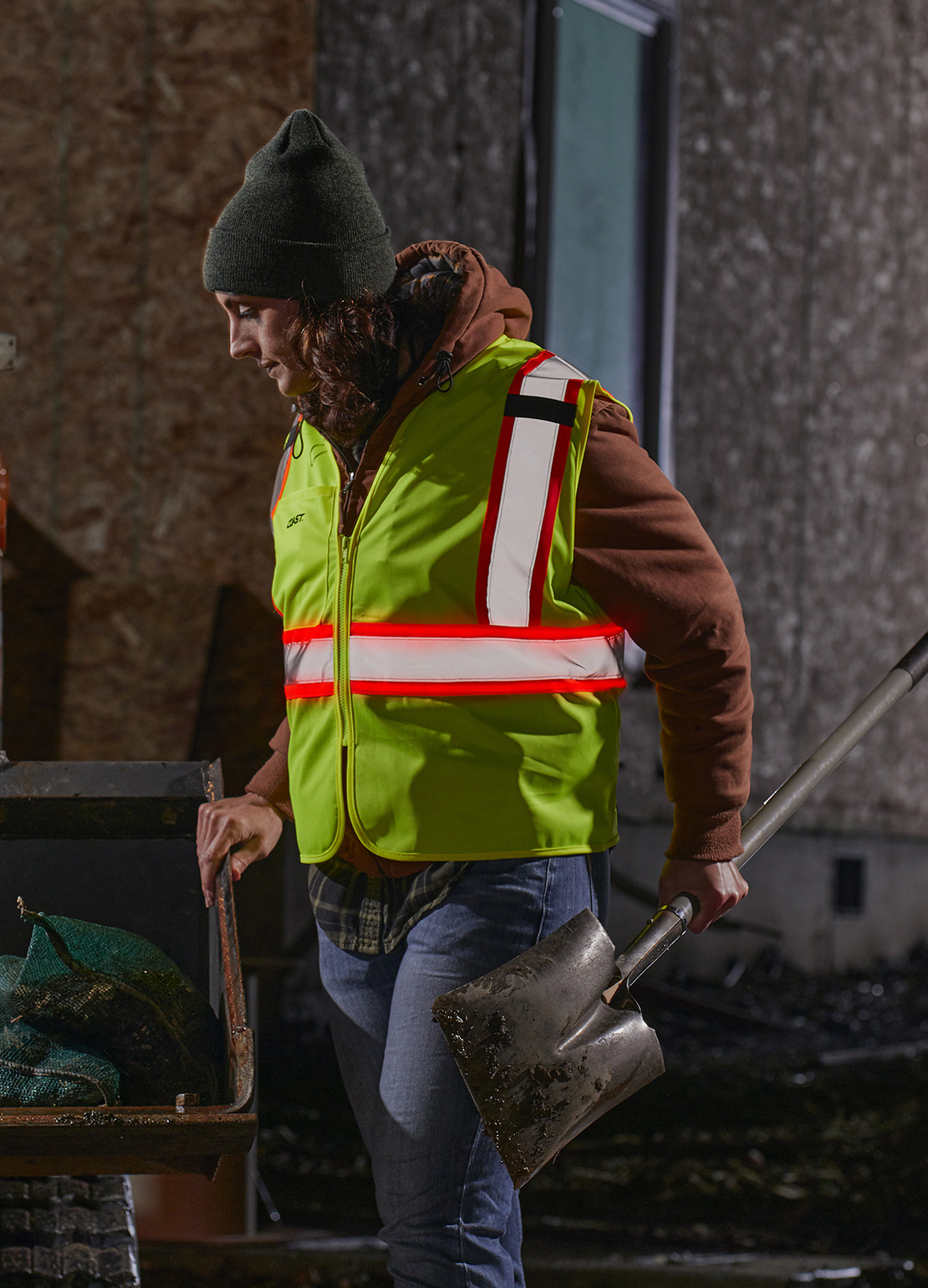 Coast Products photograph of a woman holding a shovel on a job site wearing a safety vest created by Incubate Design
