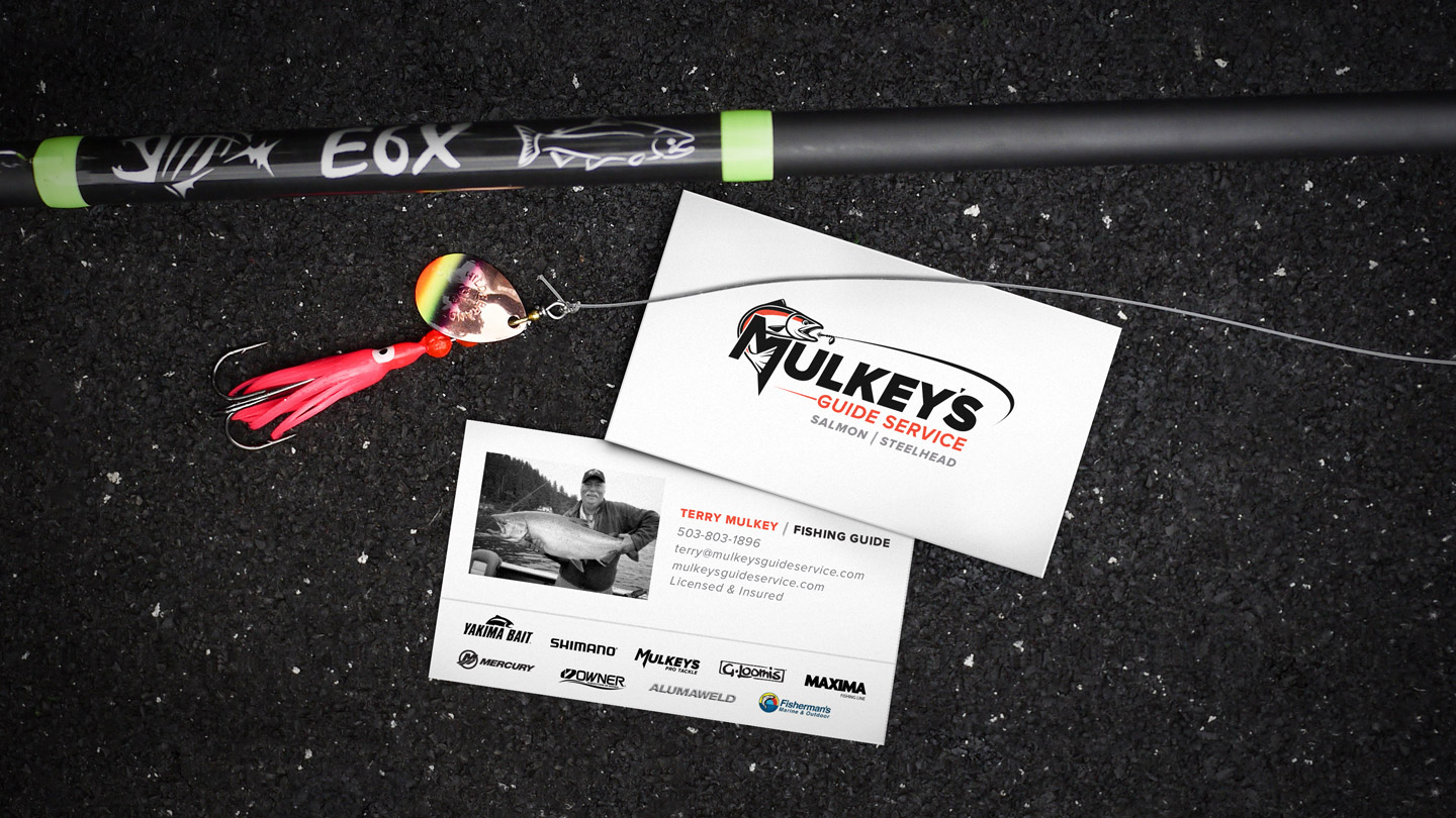 Mulkey's Guide Service business card design sitting next to fishing rod and lure.